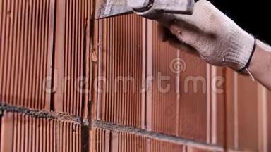 一名男子在施工现场用陶瓷块锤击墙壁。 库存录像。 工人